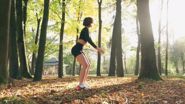 Slim Woman Doing Squats Exercises at Park