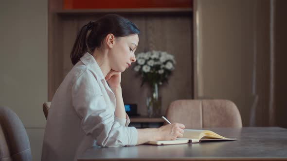 Attractive girl writing to notebook 