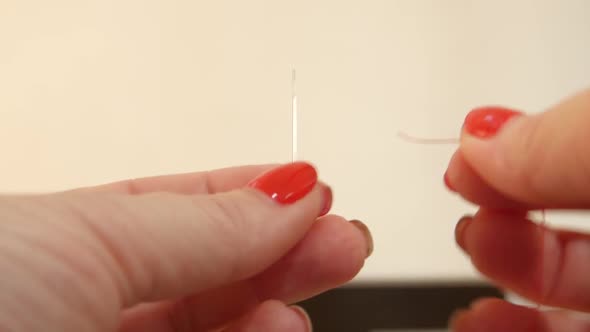 Woman Loves Doing Needlework Trying To Thread a Needle in Her Ear. Close Up