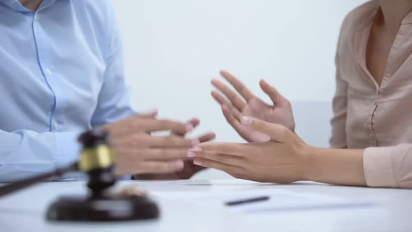 Spouses Arguing About Property Division During Divorce, Gavel and Rings Closeup