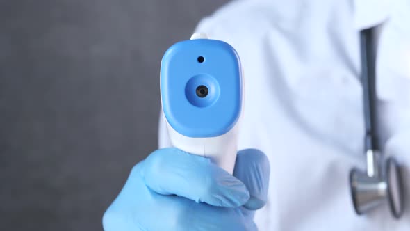 Hand Holding Infrared Thermometer To Measuring Temperature