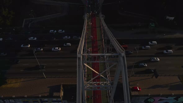 Aerial View of a Huge Foot Bridge Over the Highway with Lots of Cars Driving