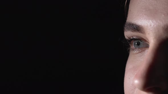 Macro Portrait of Young Tense Woman 20s Moving Blue Eyes with Dilated and Narrowed Pupils While