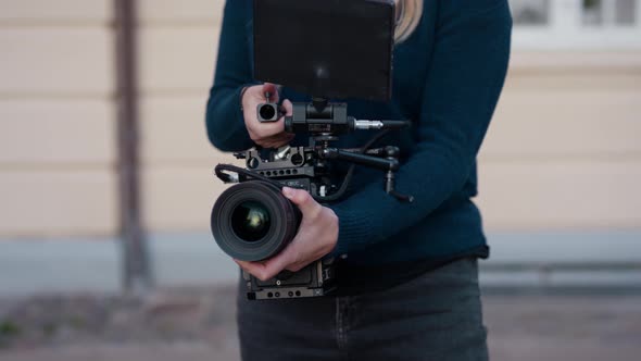 Female Film Maker Using Film Camera In Street