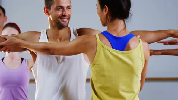 Female trainer assisting man to exercise