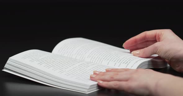 Hands turning pages of a book