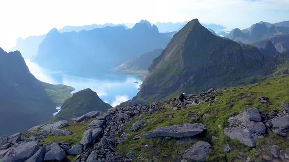 Aerial View of Girl with a Backpack Rises on a Mountain Ridge