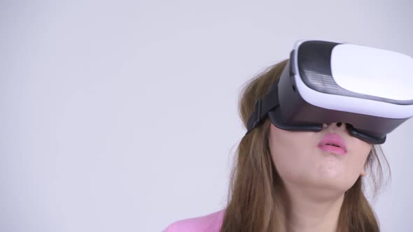 Face of Young Happy Asian Woman Looking Surprised While Using Virtual Reality Headset