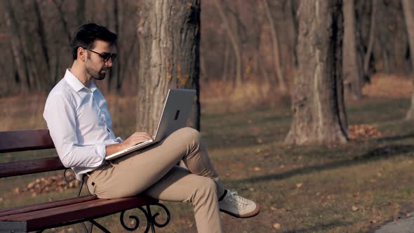 Businessman Relaxing And Reading Fresh Newspaper. Man Sitting On Bench And Reading Newspaper.