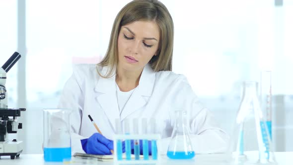 Female Scientist, Doctor Writing Details, Result of Research in Laboratory