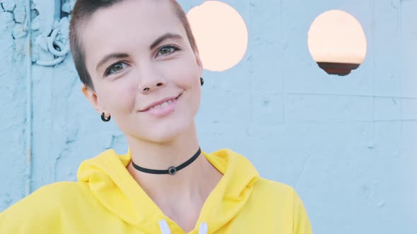 Portrait of Young Woman with Shaved Hair in Street Urban Background