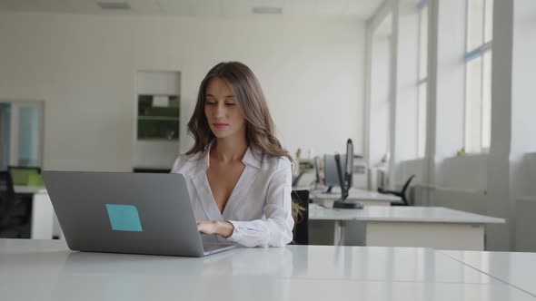 Attractive Woman Sits and Looks on the Camera