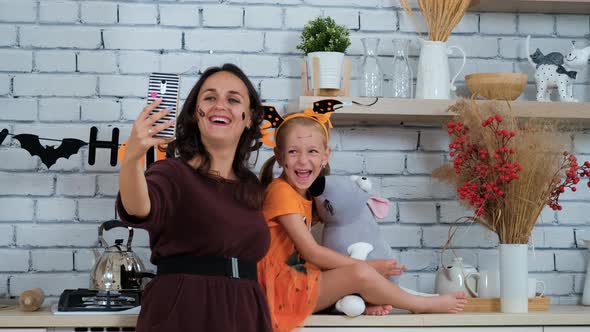 Girl with Mom in Halloween Costumes Taking Selfie