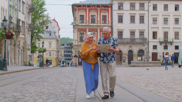 Senior Stylish Couple Tourists Man Woman Grandmother Grandfather Looking for Way Using Paper Map