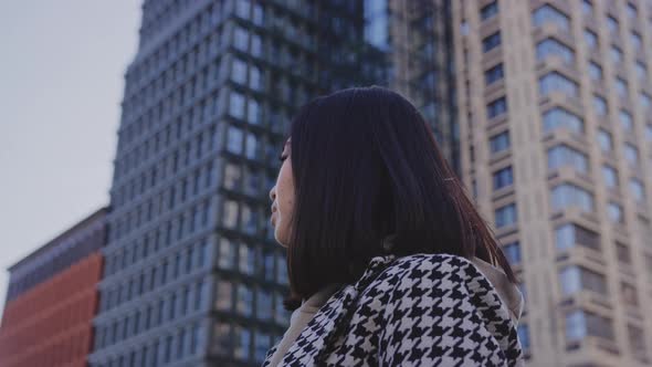 Lowangle Portrait of a Young Adult Asian Woman in Downtown District Looking Into the Camera