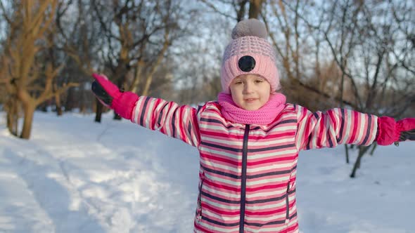 Joyful Child Kid Running Having Fun Dancing Fooling Around on Snowy Road in Winter Park Forest