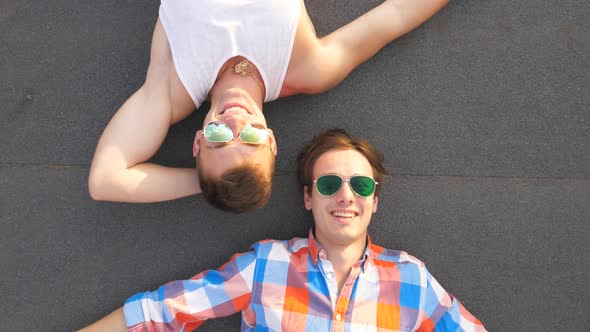 Top View of Two Handsome Guys in Sunglasses Lying with Happiness and Joy Expression on Face