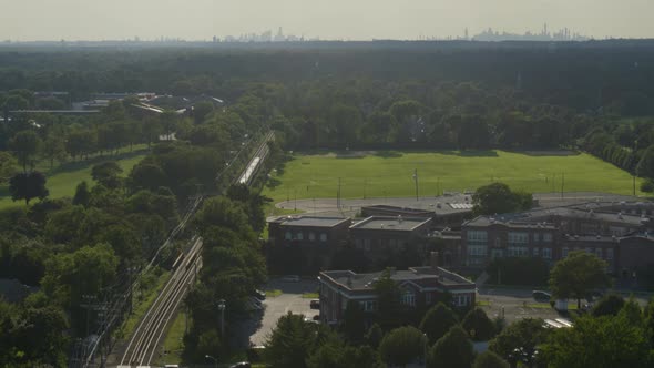 Aerial of a Train Passing Through Long Island and NYC Skyline Seen From Afar