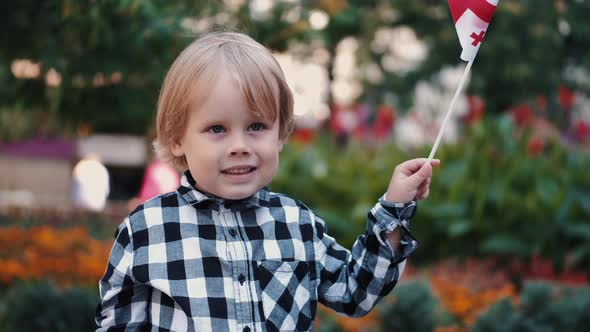 Little Boy in Checkered Shirt Holding Georgian Flag