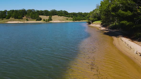 Still shot with Mavic at the shoreline of a small man-made lake.