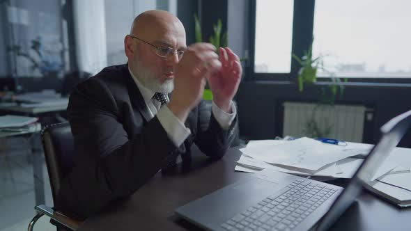 Medium Shot Portrait of Concentrated Confident Middle Aged Man Messaging Online on Laptop Taking Off