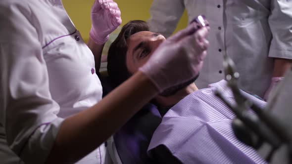 Dentist Removing Teeth Cast From Man's Mouth