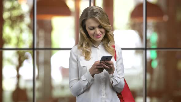Happy Smiling Young Woman Texting on Her Phone in Romaniс Mood