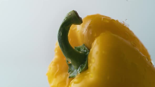 Water drops on yellow pepper. Slow Motion.