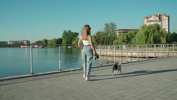 Attractive Girl Enjoying Walk with French Bulldog Near Lake.