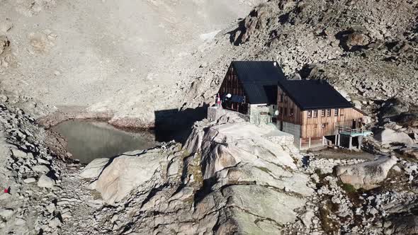 Drone panning shot of Cabane d'Orny in the swiss alps. rocky mountains, and lake