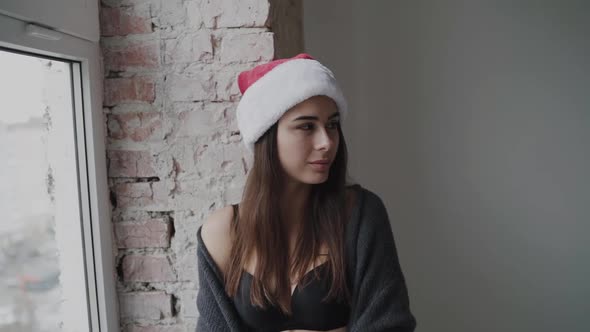 Model in New Year's Hat and Lingerie Smiling and Looking Aside at Window