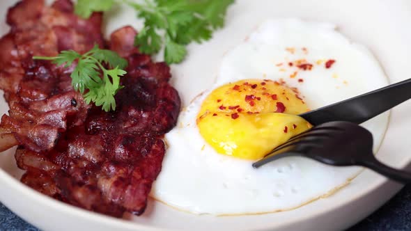 Keto Breakfast - Fried Egg, Avocado and Fried Bacon in White Plate. Keto Diet Concept.