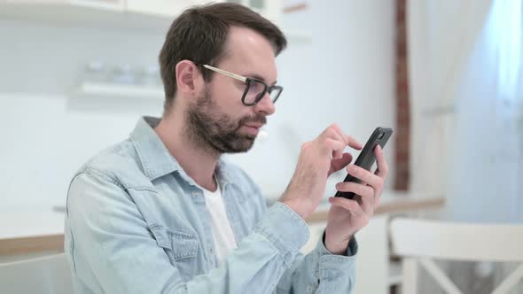 Focused Beard Young Man Using Smartphone in Office