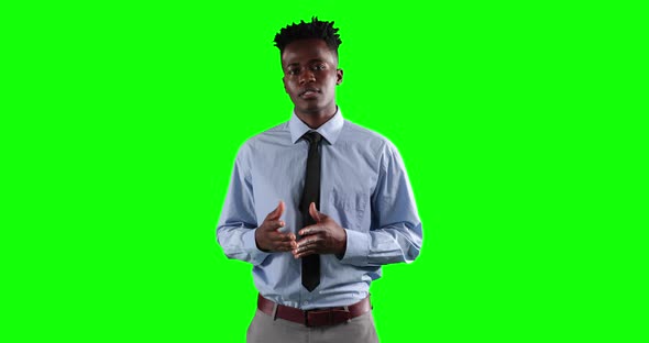 an African American man in suit talking in green background