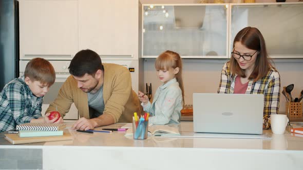 Loving Father and Mother Helping Kids with Homework Woman Using Laptop at Home