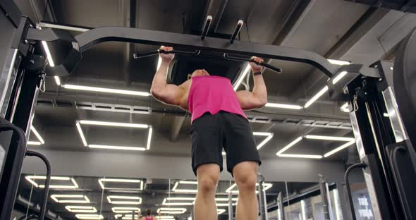 Fitness Man Pumping Up Muscle Doing Pull Ups Exercises In Gym.