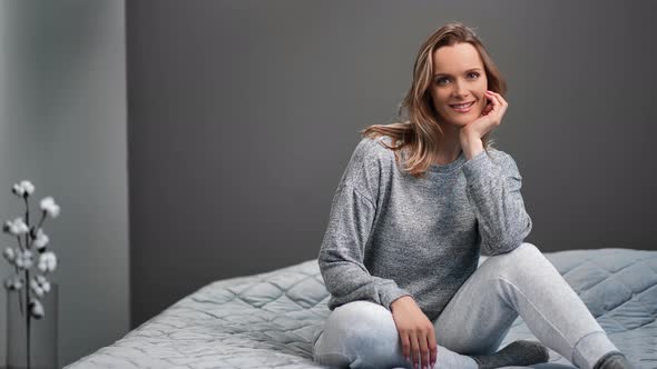 Joyful Woman Posing in Cosiness Bedroom Interior Relaxing at Home