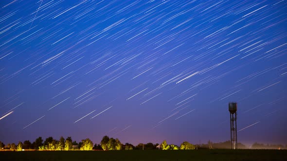 Star Lines Move In Sky Above Rural Landscape