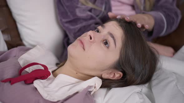 Closeup Portrait of Sad Hopeless Caucasian Young Woman Lying on Lap As Friend Caressing Hair