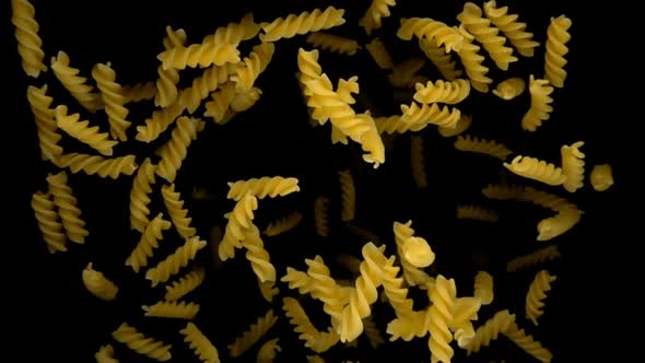 Pasta Fusilli Flies Up on Black Background