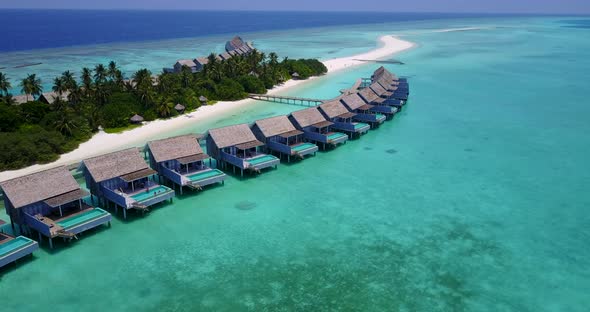 Wide angle drone clean view of a sunshine white sandy paradise beach and blue sea background in colo