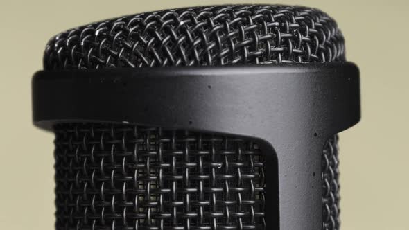 Studio Condenser Microphone Rotates on Yellow Background with Place for Text