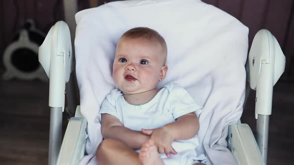 Cute Little Newborn Girl with Smiling Face Looking at Camera on White Background