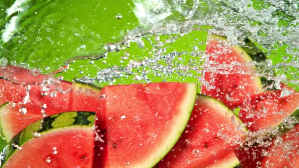 Super Slow Motion Shot of Flying Fresh Watermelon Slices and Water Side Splash at 1000Fps.