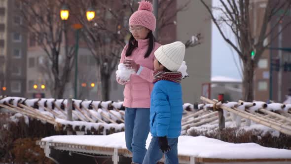 Cute Asian Children Playing Snow In The Park