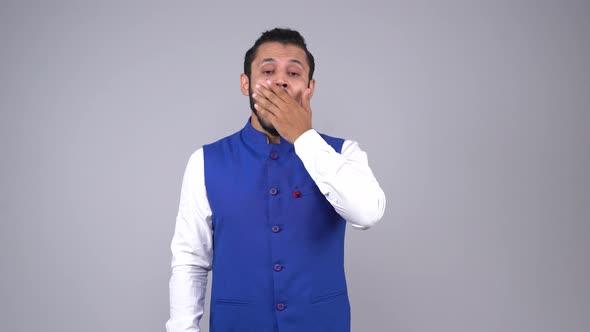 Tired Indian man yawning in an Indian outfit