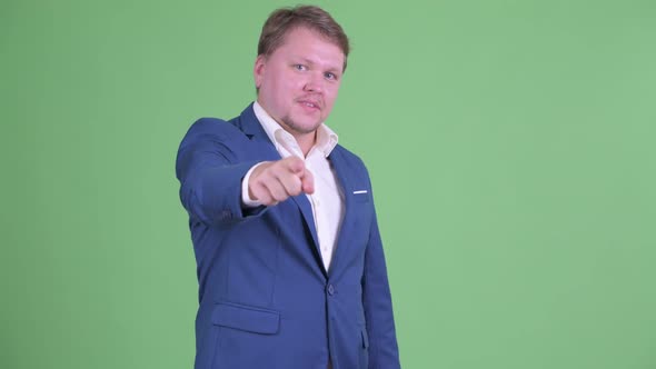 Happy Overweight Bearded Businessman Pointing at Camera