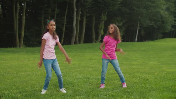 Two Little African Sisters Dancing Hip Hop in Park