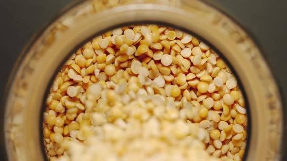 Yellow Peas Pouring Into A Glass Jar