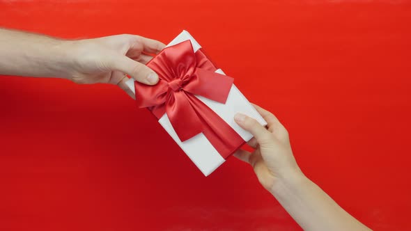 Man hand gives gift box for Valentines day or Birthday